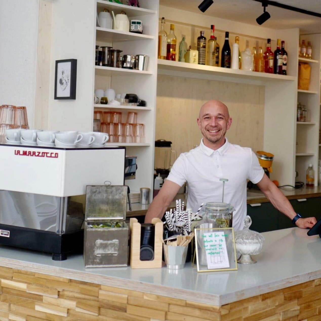 Sander achter de bar naast zijn La Marzocco-espressomachine